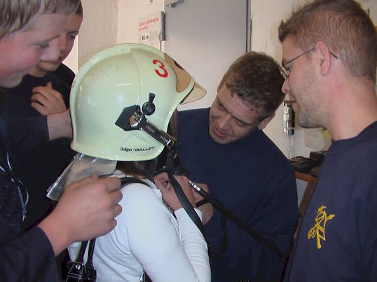 Besucher mit Helm und Atemschutzgerät